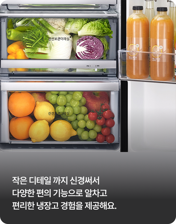 냉장고 내부의 투명한 보관 서랍 두 칸과 도어 포켓. 위쪽 서랍에는 피망, 배추, 적양배추 등 다양한 채소가 가득 차 있고, 아래쪽 서랍에는 오렌지, 레몬, 청포도, 사과, 방울토마토 등 과일이 가득 담겨 있습니다. 우측 도어 포켓에는 오렌지 주스 병들이 수납되어 있습니다.