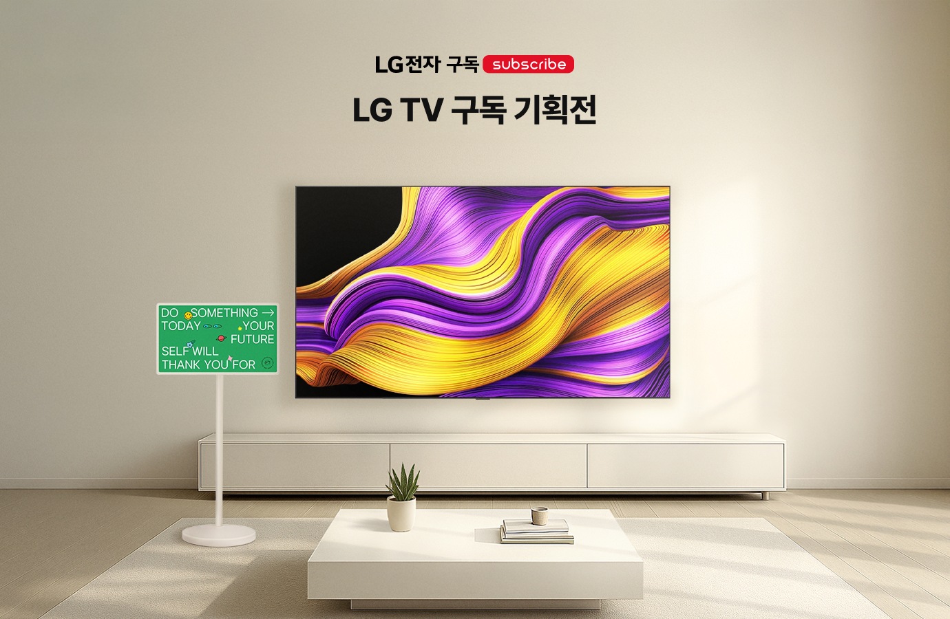 따뜻한 햇살이 비치는 베이지색 톤의 거실 인테리어. 중앙 벽면에는 대형 TV가 설치되어 보라색과 황금색이 어우러진 화려한 물결 무늬 영상을 보여주고 있음. TV 아래에는 긴 화이트 거실장이 있고, 앞쪽 낮은 테이블 위에는 작은 화분과 책, 컵이 놓여 있음. TV 왼쪽에는 세로로 된 스탠드형 스크린(스탠바이미)이 놓여 있고, 초록색 배경 화면에 'DO SOMETHING TODAY YOUR FUTURE SELF WILL THANK YOU FOR'라는 영문 문구와 스마일, 눈 모양 등의 아이콘이 장식되어 있음.