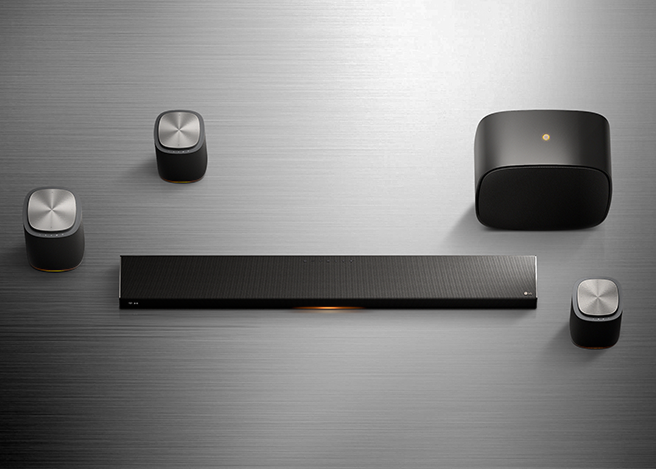 메탈 질감 배경에 LG Sound Suite M7,M5,H7,W7 제품이 흩어져서 배치되어있습니다.