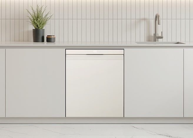 베이지색으로 인테리어된 주방 선반 위에 왼쪽에는 화분, 오른쪽에는 싱크대가 있고 아래에는 식기세척기가 있다.